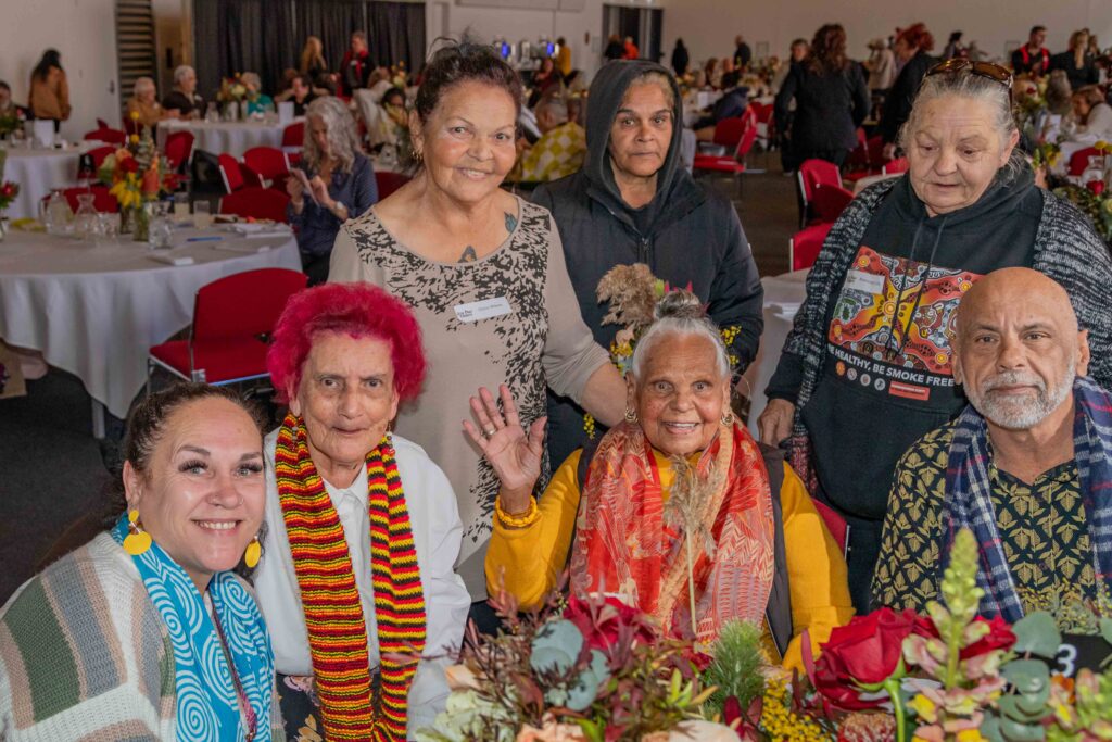 Elders gather around a table at Aboriginal Community Service's 2023 NAIDOC week celebration lunch at the Adelaide Convention centre.